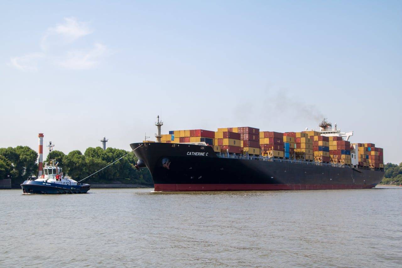 A container ship is guided by a tugboat on the Elbe River in Hamburg, Germany.