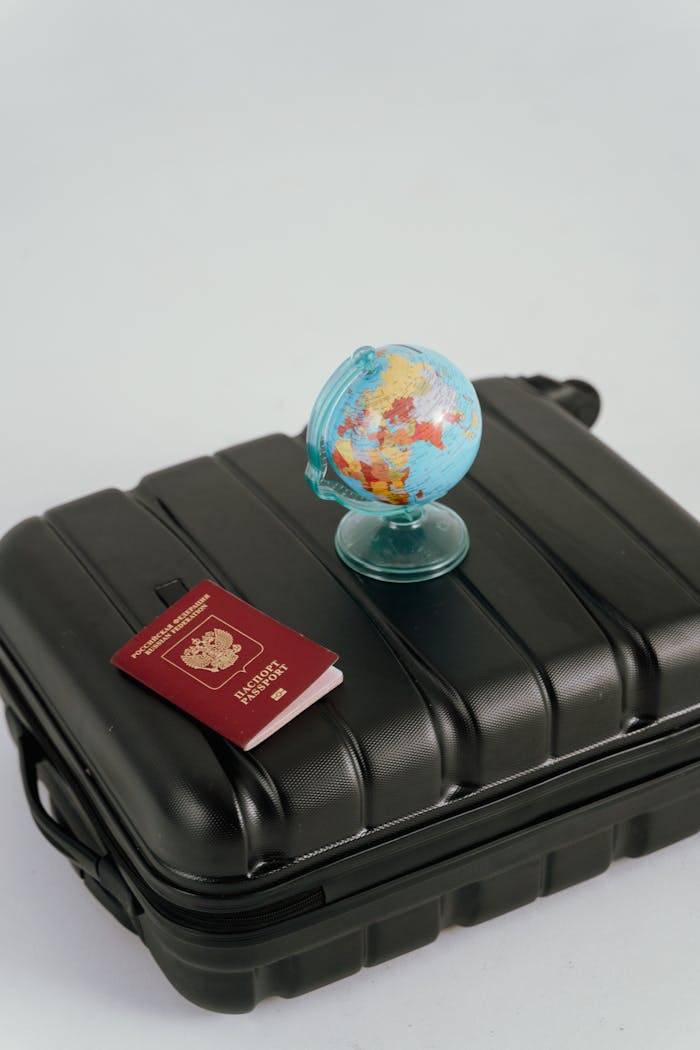 services-04 A passport, luggage, and mini globe symbolize travel planning and wanderlust.
