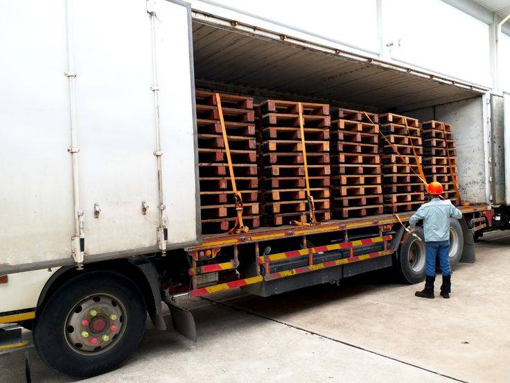 Double wing wooden pallets stacked for heavy-duty transport and warehouse storage.
