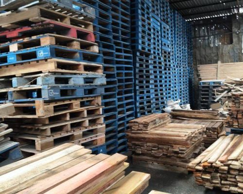 Heavy duty plastic pallets stacked in a warehouse, designed for industrial storage and transport.